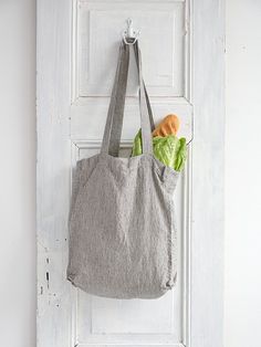 a tote bag hanging on a white door with vegetables in the front and behind it