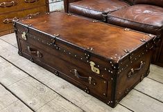 a brown leather trunk sitting on top of a wooden floor