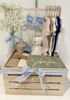 a teddy bear sitting on top of a wooden crate filled with clothes and other items