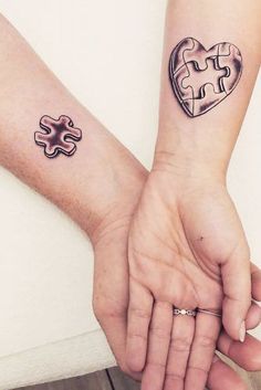 two people holding hands with puzzle pieces on their wrists and one has a heart shaped piece in the middle