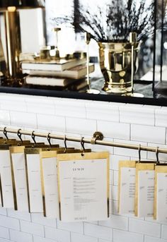 there are many menus hanging on the rack in front of the window, along with other items