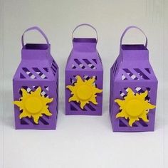 three purple lanterns with yellow sun decorations on them