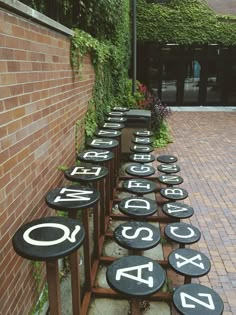 a row of black and white numbers sitting on top of a brick sidewalk next to a building