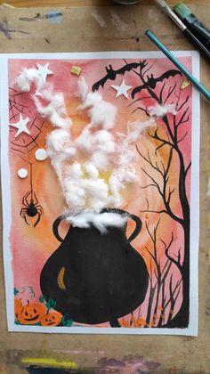 an art project with cotton in a black pot and spooky spider webs