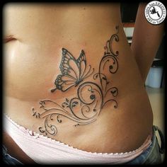 a woman's stomach with a butterfly tattoo on the side and an intricate design