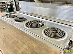 an industrial stove with four burners in a kitchen