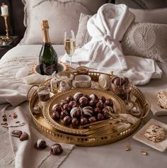 a tray with chocolates and champagne on a bed