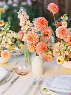 the table is set with flowers in vases