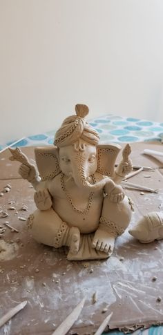 an elephant statue sitting on top of a table next to some construction tools and paper