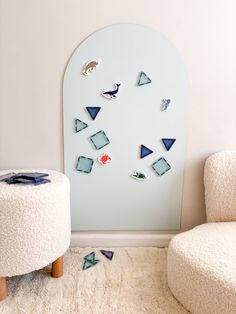 a white chair sitting next to a wall with blue and red shapes on it's side