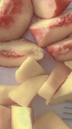 pieces of cheese and slices of fruit on a white plate with a fork next to it