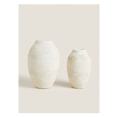 two white vases sitting next to each other