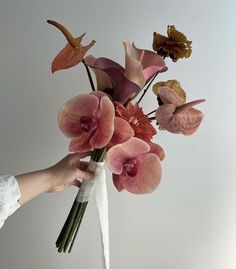 a person holding a bouquet of flowers in their hand