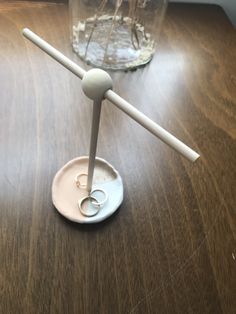 two wedding rings are placed on top of a wooden table next to a vase with flowers in it