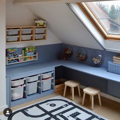 a child's playroom with toys and storage space in the corner, under a slanted roof