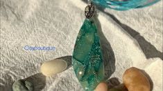 a piece of green glass sitting on top of a white cloth next to some rocks