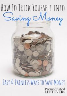 a glass jar filled with coins sitting on top of a white table next to a pink ribbon