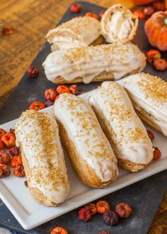 several pastries are arranged on a plate with pumpkins and other autumn decorations in the background