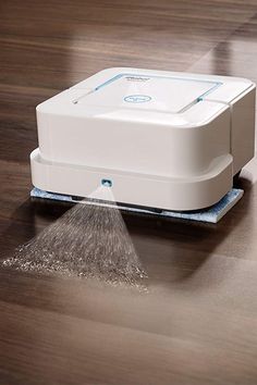 a close up of a floor scruber on the ground with water coming from it