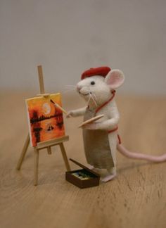 a toy mouse is painting on an easel