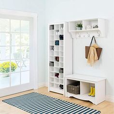 a white entryway with a black and white striped rug on the floor next to it