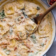 a skillet filled with ravioli and spinach