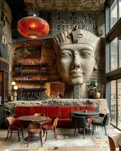 the interior of a restaurant with an egyptian head on the wall and red couches