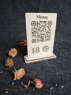 a table with dried flowers on it and a menu holder in the middle that says menu