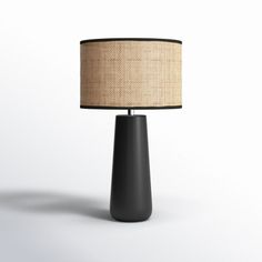 a black table lamp with a beige shade