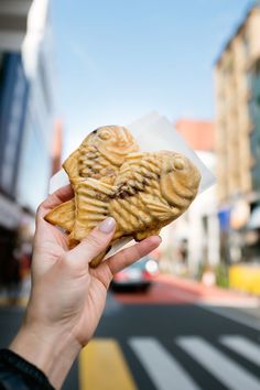 a person holding up a heart shaped cookie in front of a city street with the words, a foodie's guide to tokyo, japan