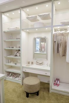 a dressing room with white walls and shelves filled with clothes, shoes, and other items