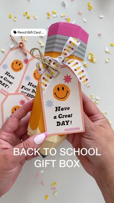 the back to school gift box is being held by someone's hand with confetti on it