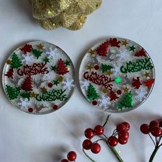 two christmas themed plates sitting on top of a table next to berries and gold decorations