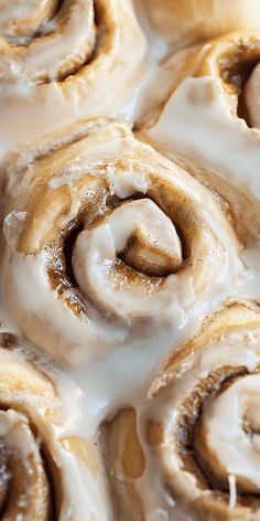 cinnamon rolls with icing sitting on top of each other