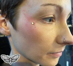 a close up of a person with piercings on their ears and nose, looking at the camera