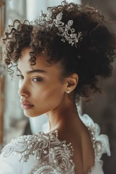 a woman with curly hair wearing a tiara and looking off to the side, in front of a window