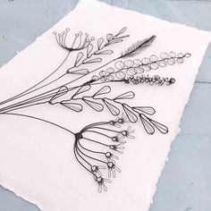 some flowers are sitting on top of a piece of paper with black and white ink