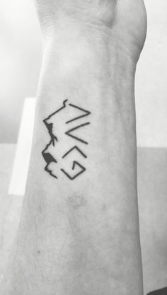 a black and white photo of a person's arm with a tattoo on it