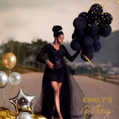 a woman in a black dress is holding balloons and some gold foil stars on the ground