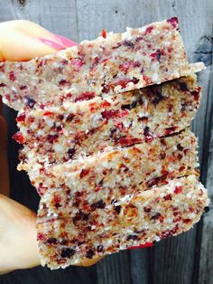 someone holding up some kind of granola bar in front of a wooden fence,