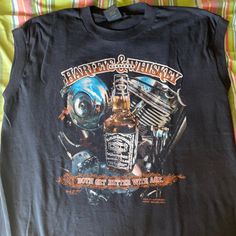 an old harley davidson shirt is laying on a bed with the words harley and whiskey printed on it