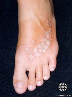 a woman's foot with white flowers on it