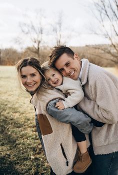 a man and woman holding a child in their arms