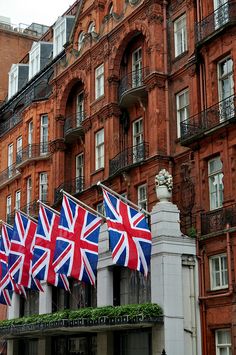 the british flag is flying in front of an old building