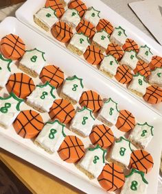 two trays filled with cookies decorated like basketballs and numbers on top of each other