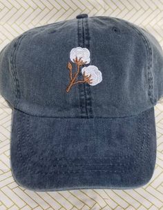 Cotton branches are in this season! Perfect for the southern belle trying to keep the sun and messy hair out of her face! Hat pictured is Navy. These hats are Adams brand. They are 100% cotton twill, garment washed and pigment dyed. These are a low profile with a mesh lining. The back has a tuck-away leather strap with a brass buckle. (seen in picture #4) Hat colors available in picture #2. NEW Spring/Summer hat colors available in picture #3. (Neon Pink, Neon Yellow, Neon Green, Tangerine) Cotton Snapback Beach Hat, Cotton Snapback Hat For Beach, Trendy Cotton Trucker Hat For Beach, Cotton Beach Hat With Curved Bill, Beach Cotton Hat With Curved Bill, Cotton Curved Bill Beach Hat, Cotton Beach Baseball Cap, Adjustable Cotton Brimmed Hat, Embroidered Logo Cotton Snapback Hat