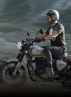 a man riding on the back of a silver motorcycle