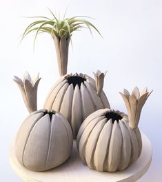 three ceramic pumpkins sitting on top of a table