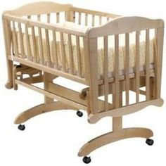 a wooden baby crib with wheels on it