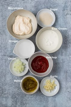 the ingredients to make this recipe are shown in bowls on a gray surface, including mayonnaise, sour cream, sour cream and other condiments